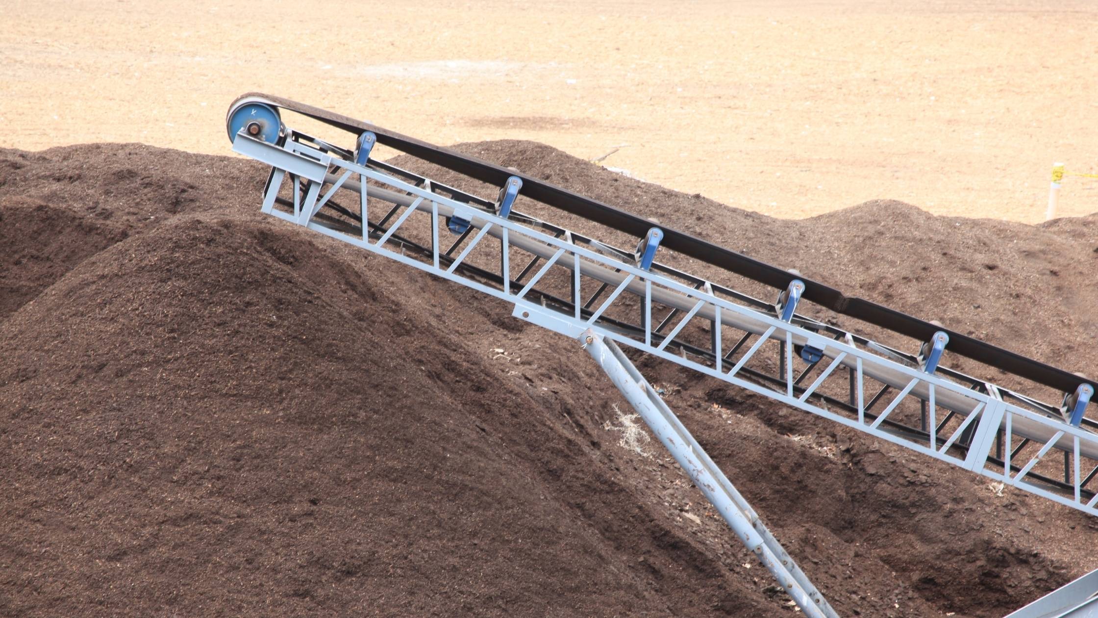 A conveyor belt transporting topsoil