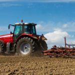 A tractor busy plowing a field.