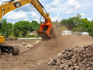 An excavator picking up dirt with the SB16 screening bucket.