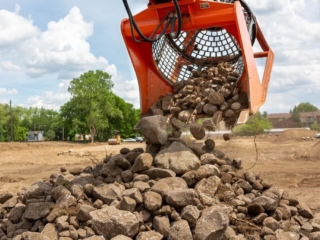 The SB16 Screening Bucket busy pouring out rocks after sifting the soil.