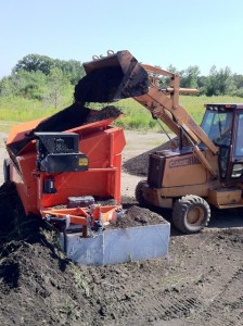 A loader bulldozer busy pouring dirt into the EZ-Screen 700. 
