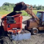 An excavator poring dirt into an EZ-Screen 700