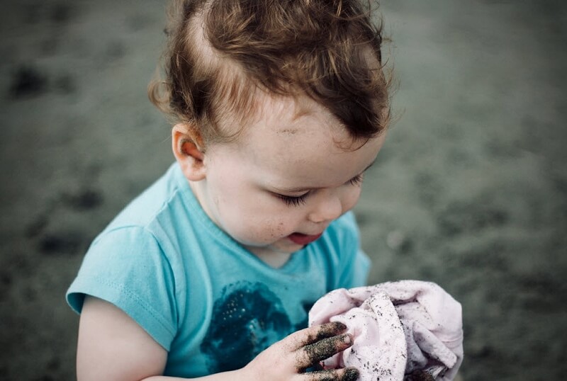 An image of a child playing in the dirt. 